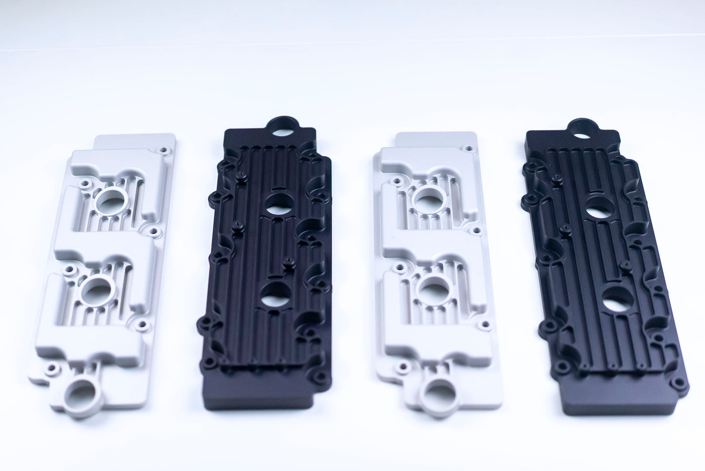 Metal valve covers in black and silver on white background