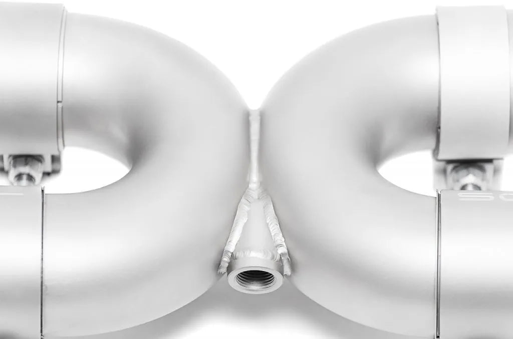 Close up of Soul Performance sport exhaust system X-pipe welds in silver for Porsche 993 on a white background.