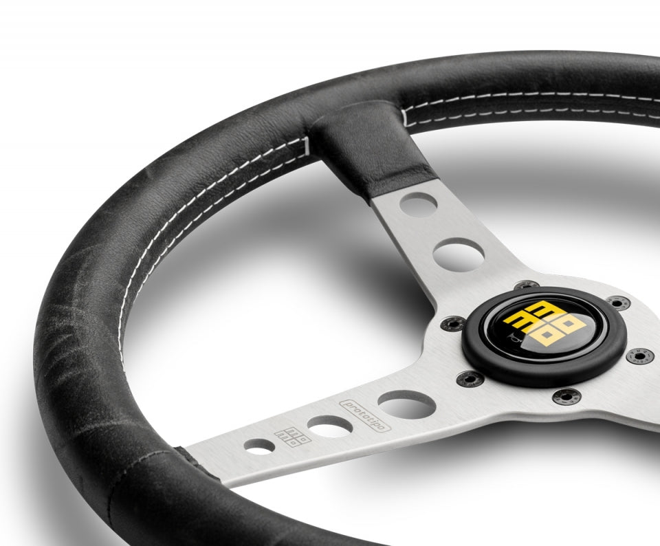 Momo heritage prototipo steering wheel black with silver center spokes in white background.