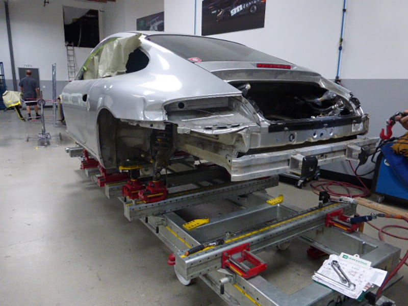 Close-up of a Porsche 996 911 rear body panels removed and windows masked off for paint prep.