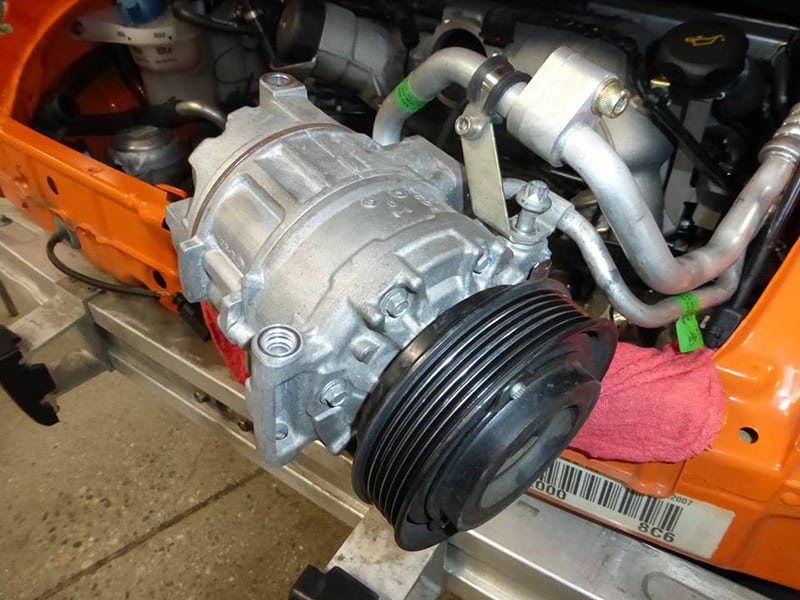 Close-up of a 911 engine with a pully pulled out of engine bay.