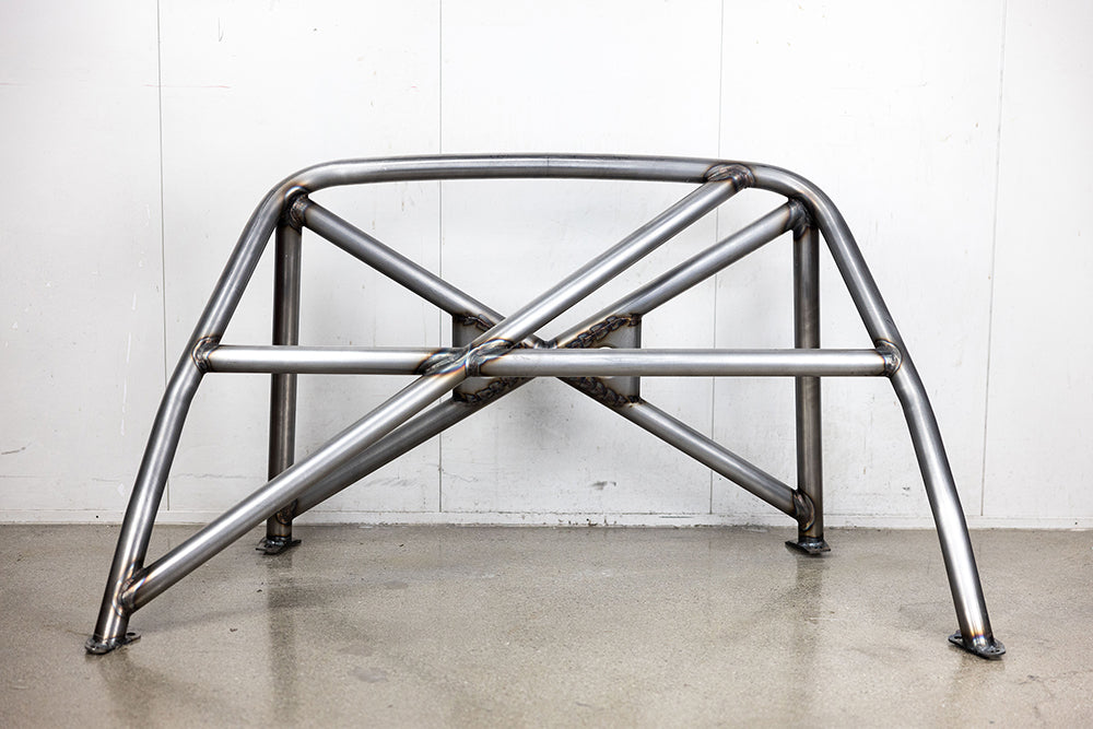 911 Design roll cage in raw metal on shop floor.