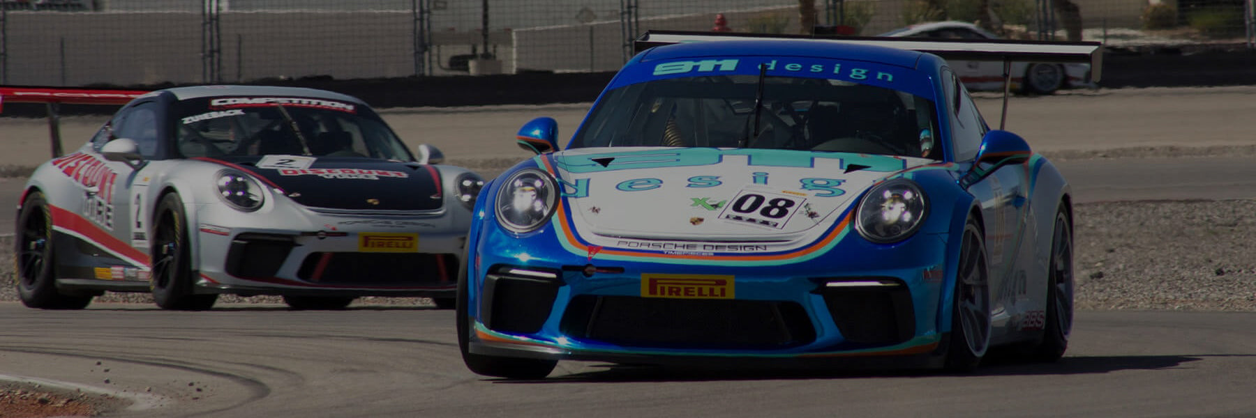 Two Porsche 911 GT3 race cars on a track with one prominently featuring the 911 Design logos.