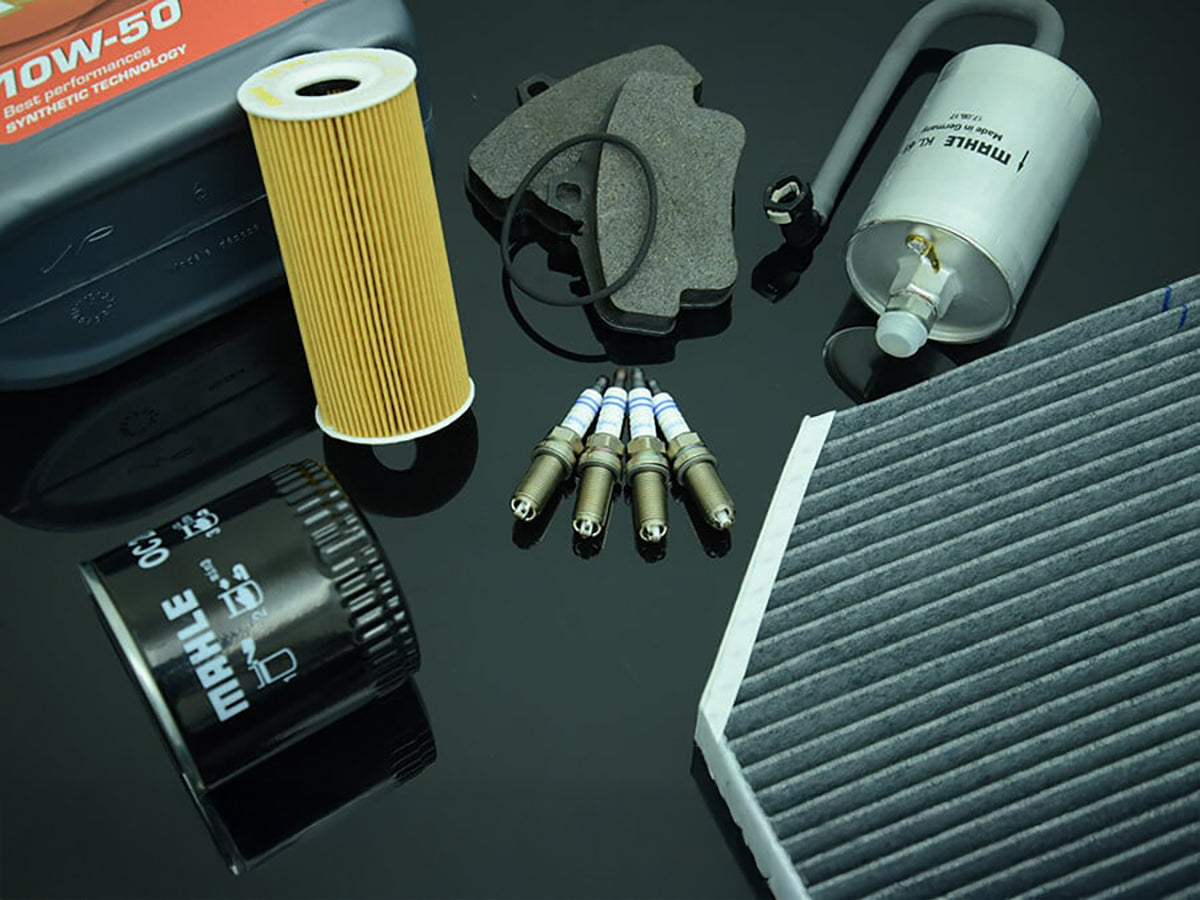 Collection of Mahle oil filters, synthetic oil, and basic maintenance parts for Porsche on table.