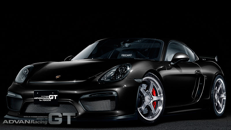 Black Porsche Cayman on silver Advan GT for Porsche wheels in black background.