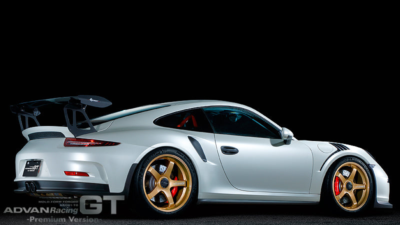 White Porsche 991 GT3 with gold Advan GT for Porsche wheels in black background.