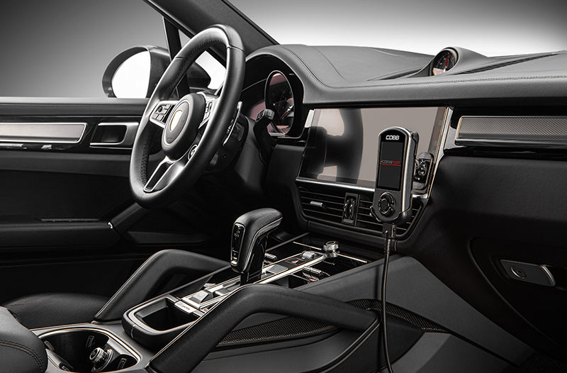 Close up of COBB Tuning Accessport installed inside Porsche Cayenne 9Y0 interior on right side dash.