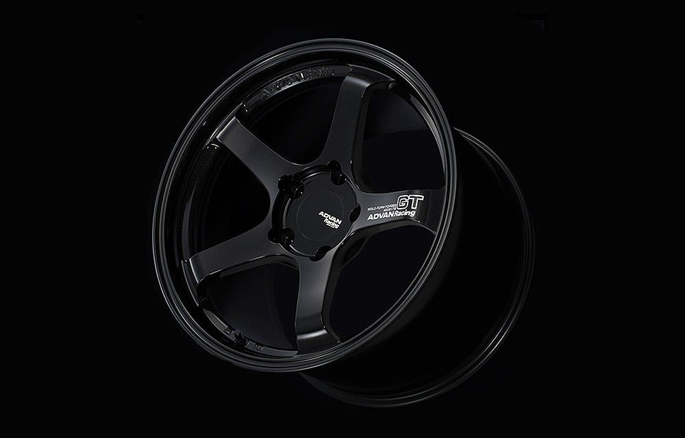 Advan GT for Porsche wheel in Racing Gloss Black in black background.