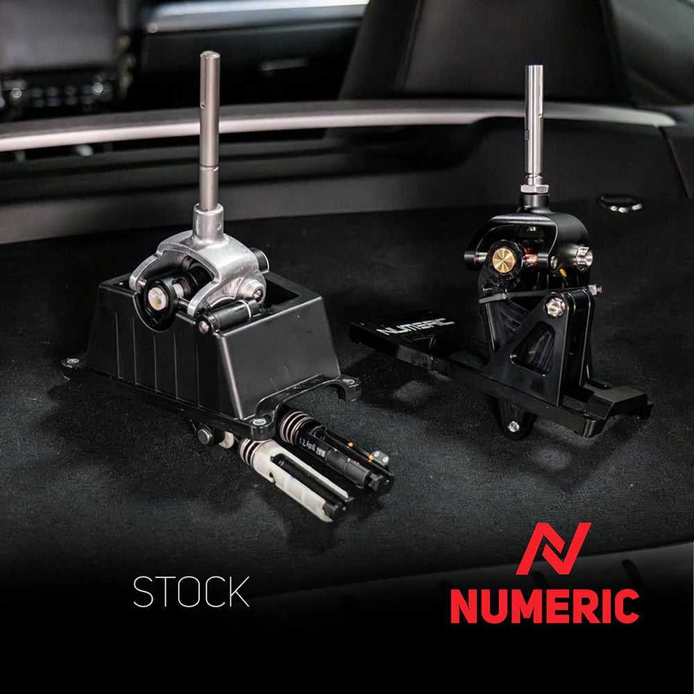 Numeric short throw shifter assembly side by side next to a stock shifter assembly inside the rear of a Porsche Cayman.