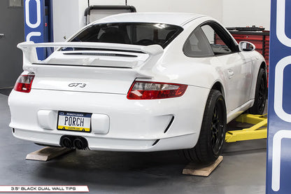 Soul Performance center muffler bypass exhaust system with black exhaust tips installed on white Porsche 997 911 GT3 on garage lift.