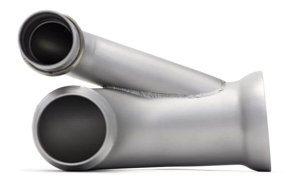 Close up of inlet and outlet of Soul Performance side muffler bypass exhaust pipes in silver for Porsche 911 GT3 on a white background.