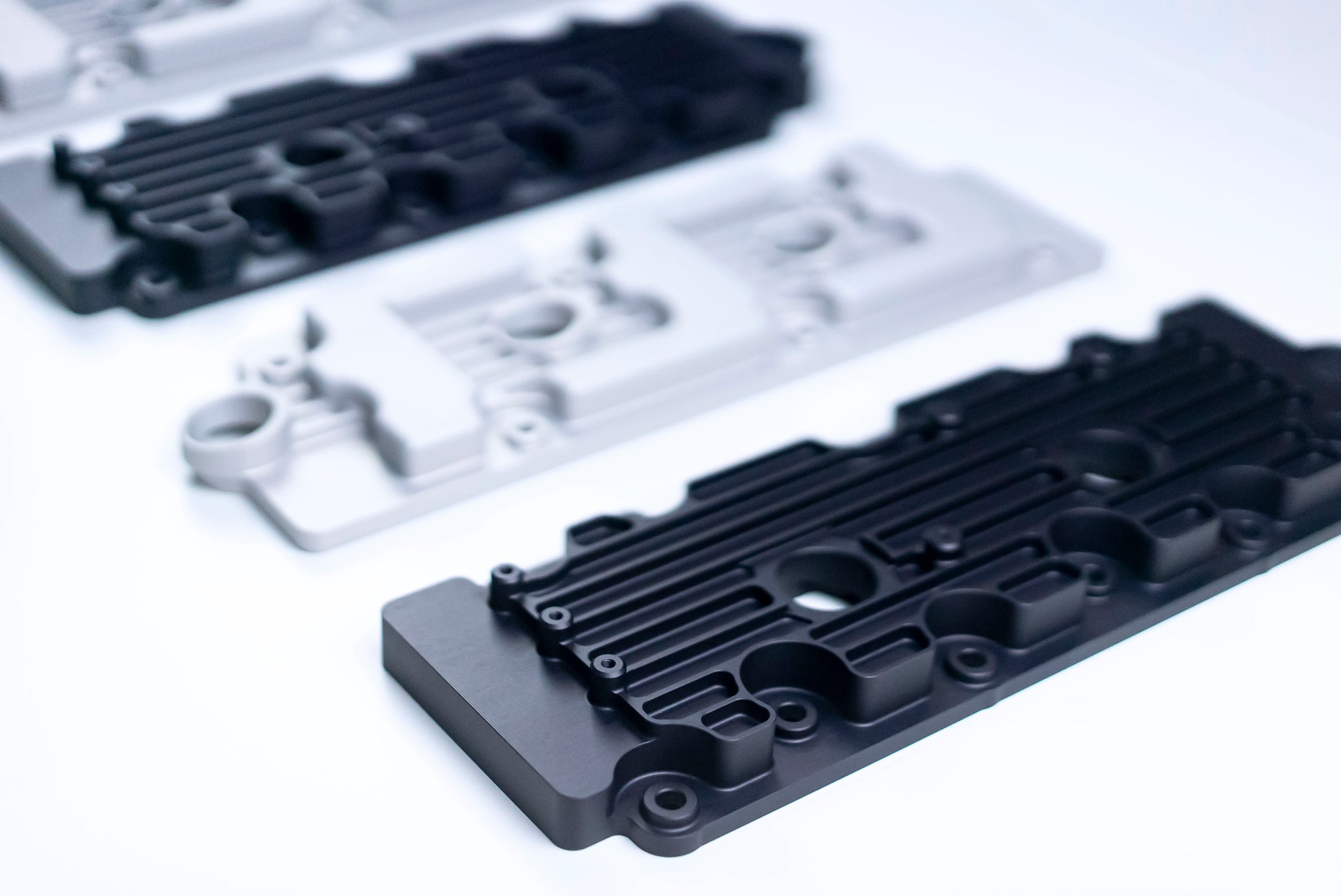 close up of Metal valve covers in black and silver on white background