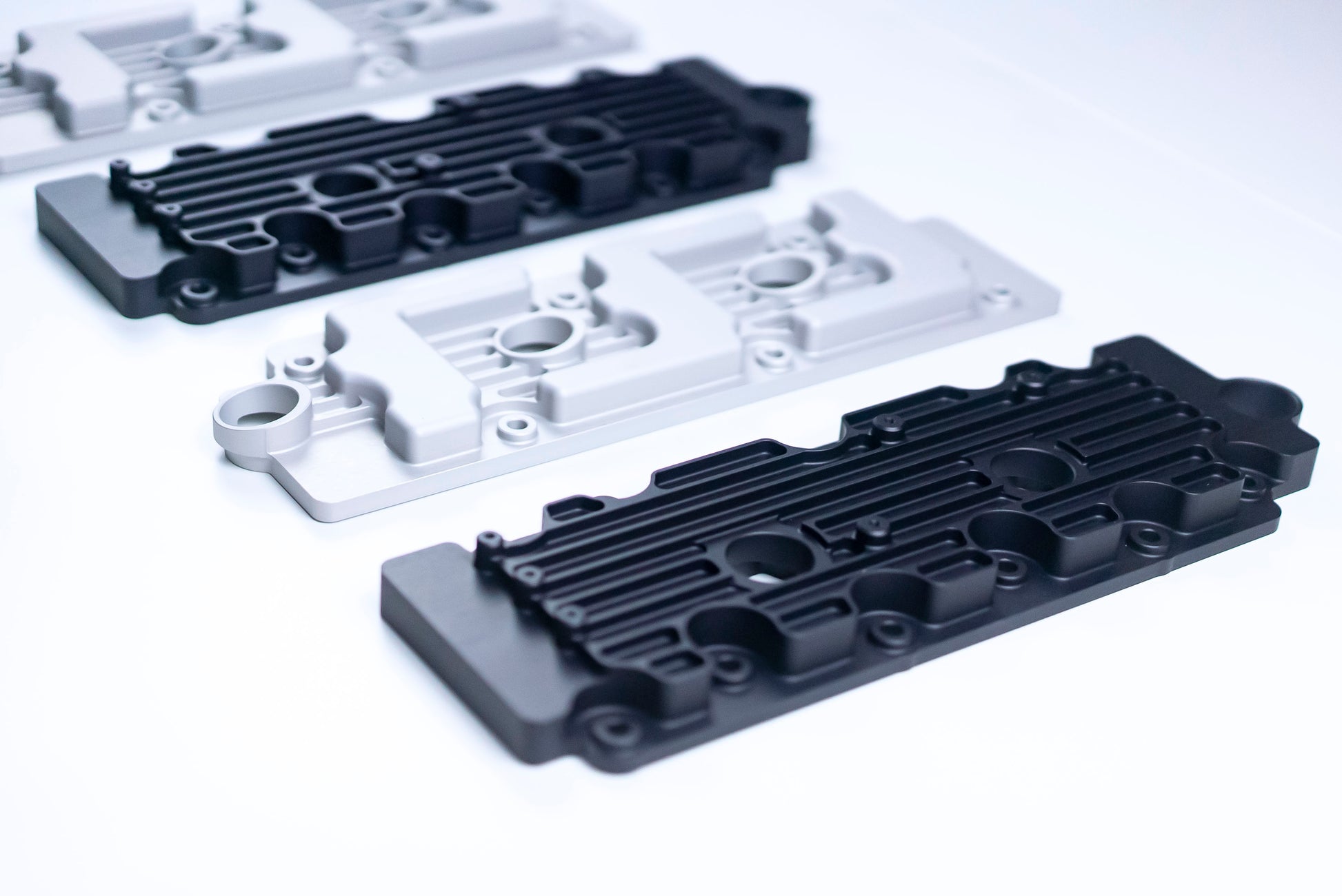 close up of Metal valve covers in black and silver on white background