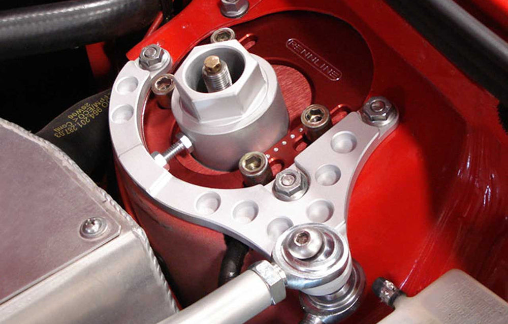 Close-up of a rennline strut bar mount in a red Porsche bay.