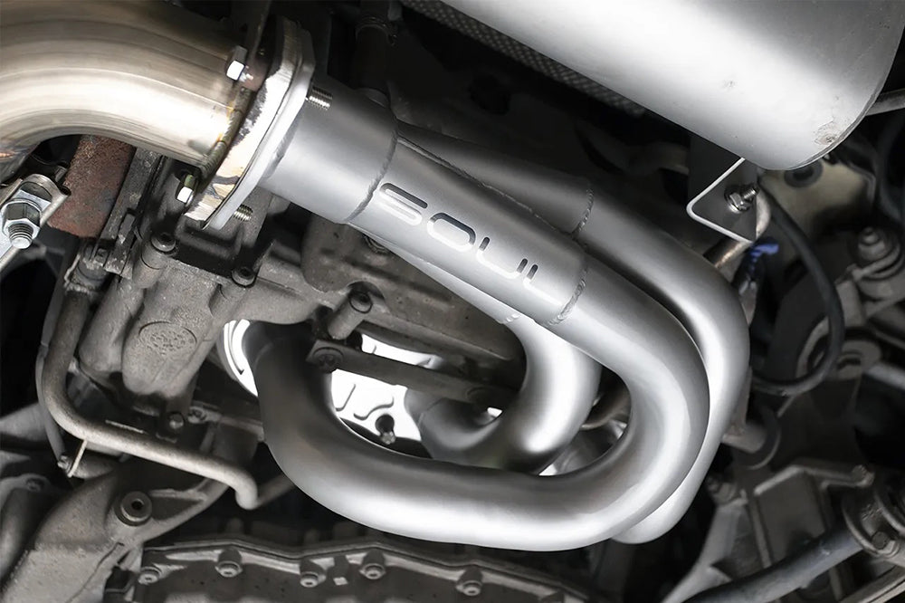 Close-up of a Soul performance competition headers installed on Porsche with logo visible.