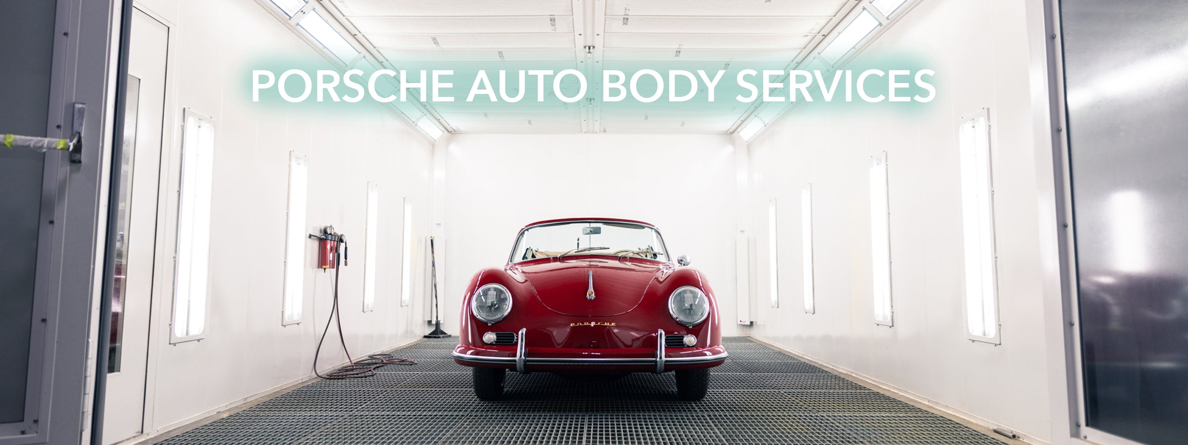 Red Porsche classic inside a spray booth with 'Porsche Auto Body Services' text above.