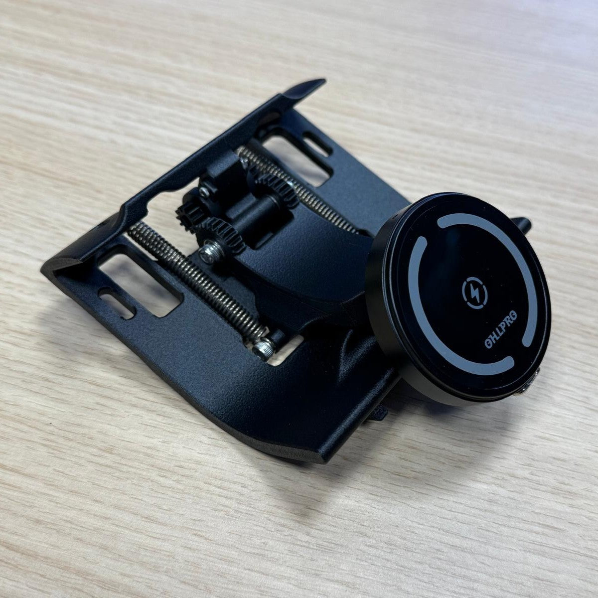 Triebwerk fold-out smartphone holder for Porsche 964 with wireless charging displayed on wooden table.