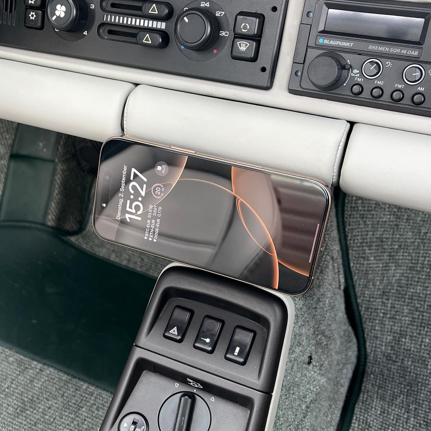 Phone mounted horizontally in Triebwerk wireless charging holder in Porsche 964 interior