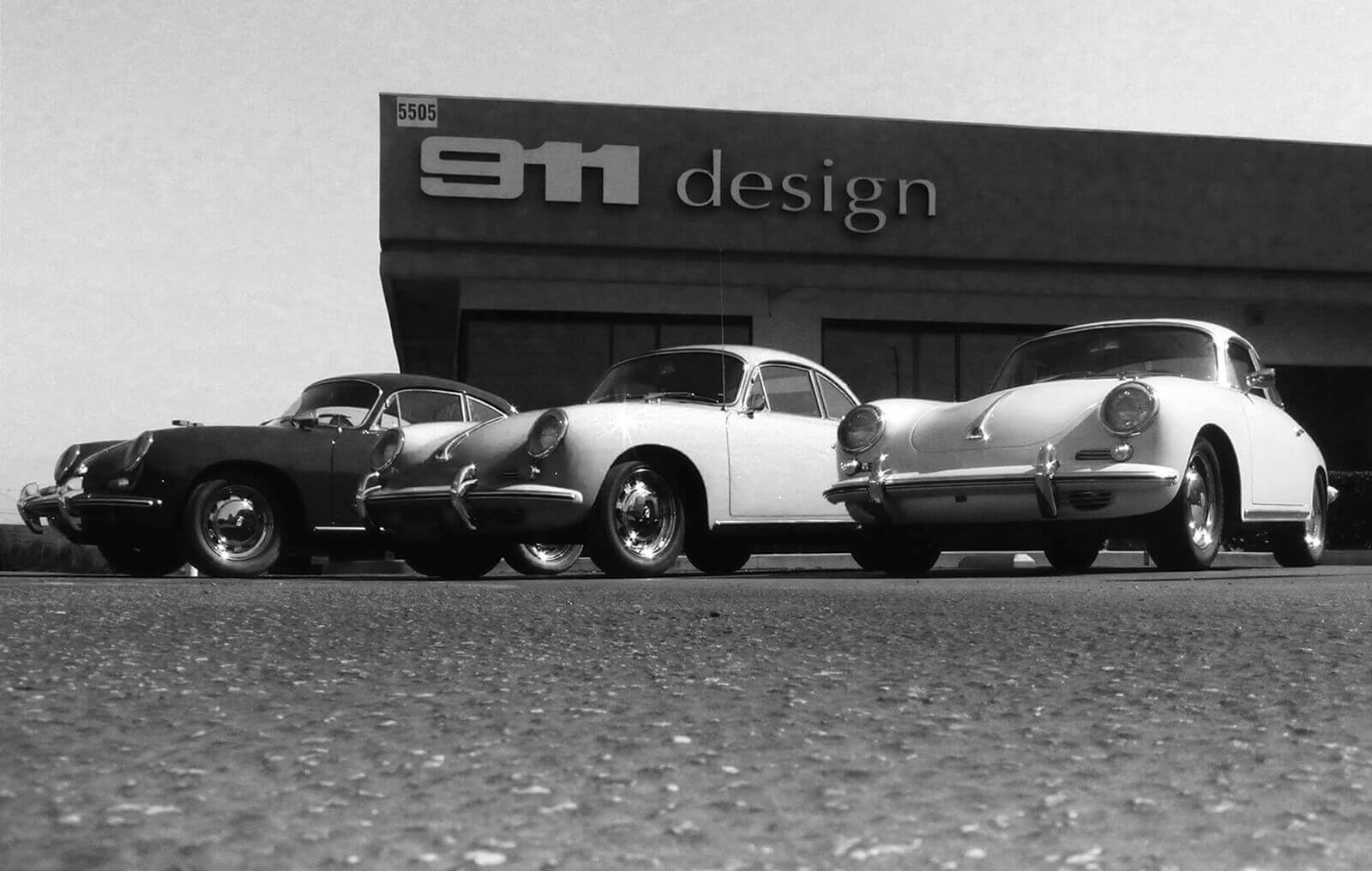Three classic Porsches parked in front of 911 Design building.