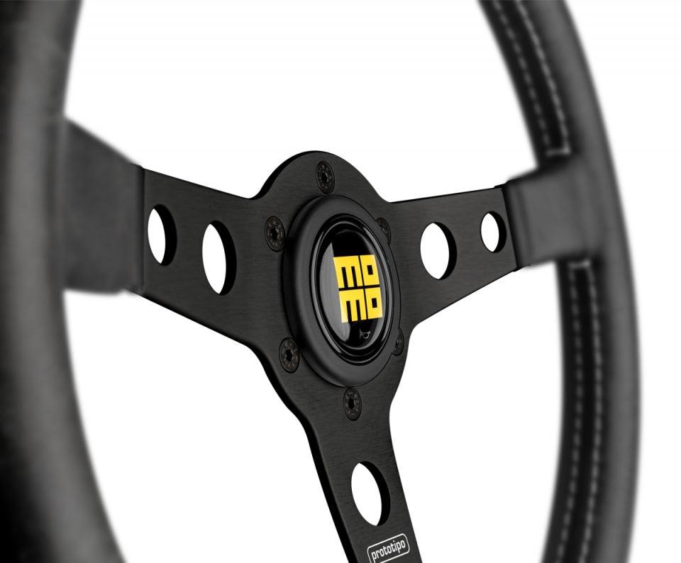 Close up of Momo heritage prototipo steering wheel black center with momo horn button in yellow.