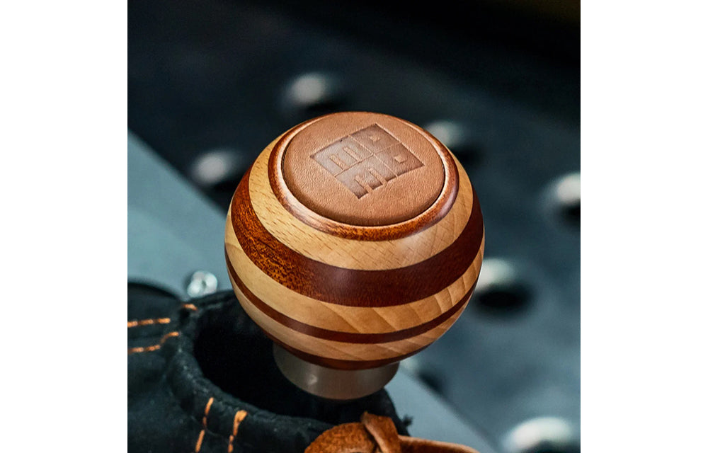 Momo Targa Heritage wood shift knob with Momo logo on a leather top insert installed on car.