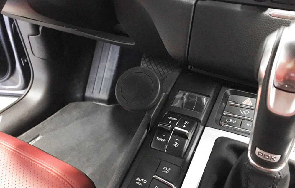 Rennline magnetic phone mount installed in left side of center console in a Porsche Macan interior.