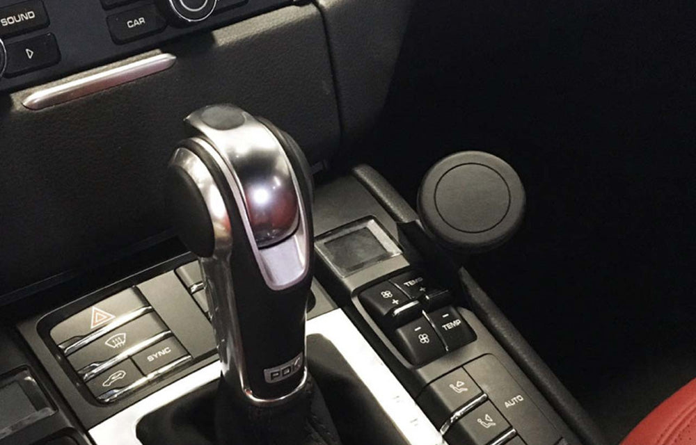 Rennline magnetic phone mount installed on right side of center console in a Porsche Macan interior.