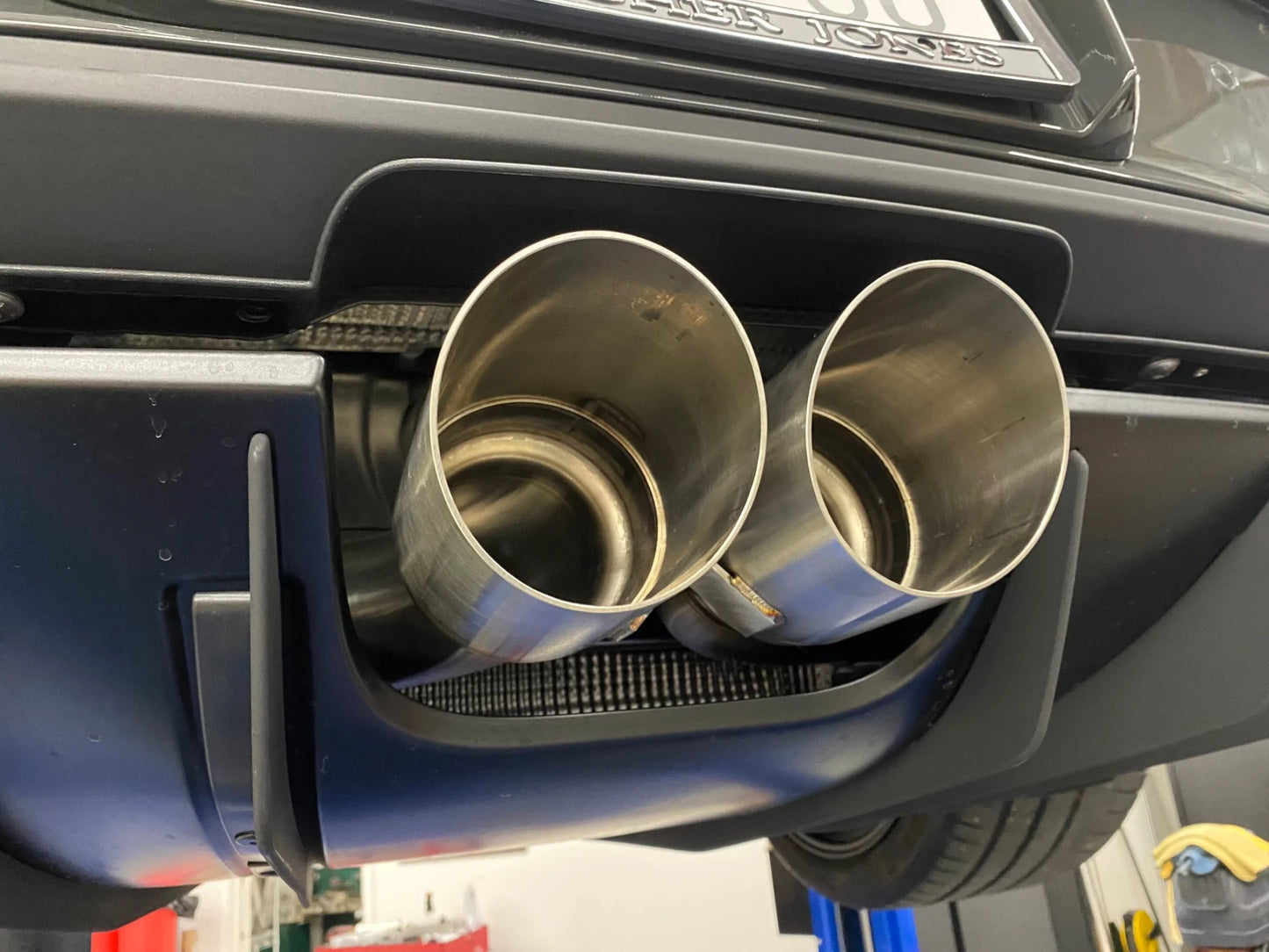 Close up of Shark Werks titanium center muffler bypass exhaust with exhaust tips installed on Porsche.