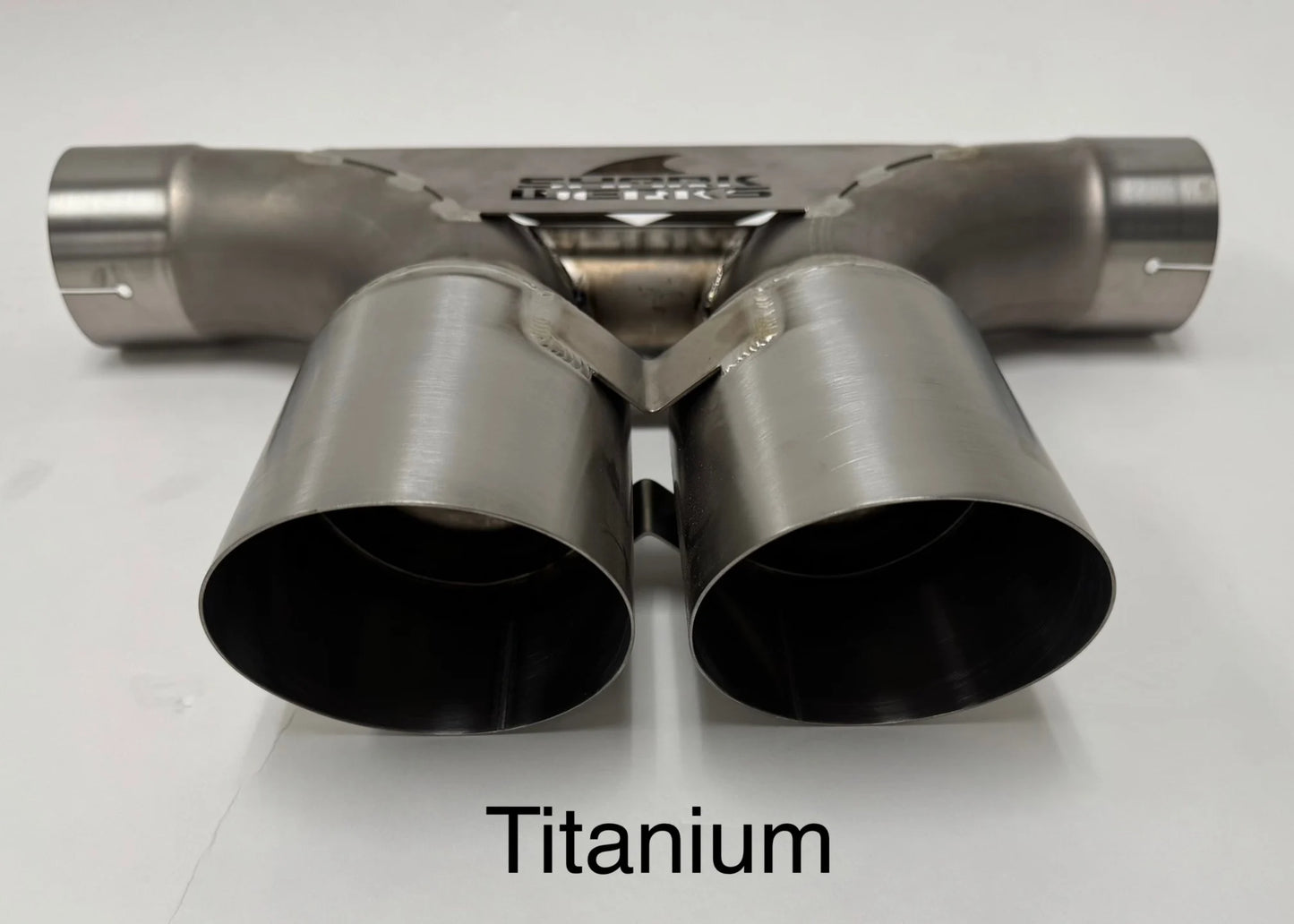 Close up of Shark Werks titanium center muffler bypass exhaust with exhaust tips on white background.